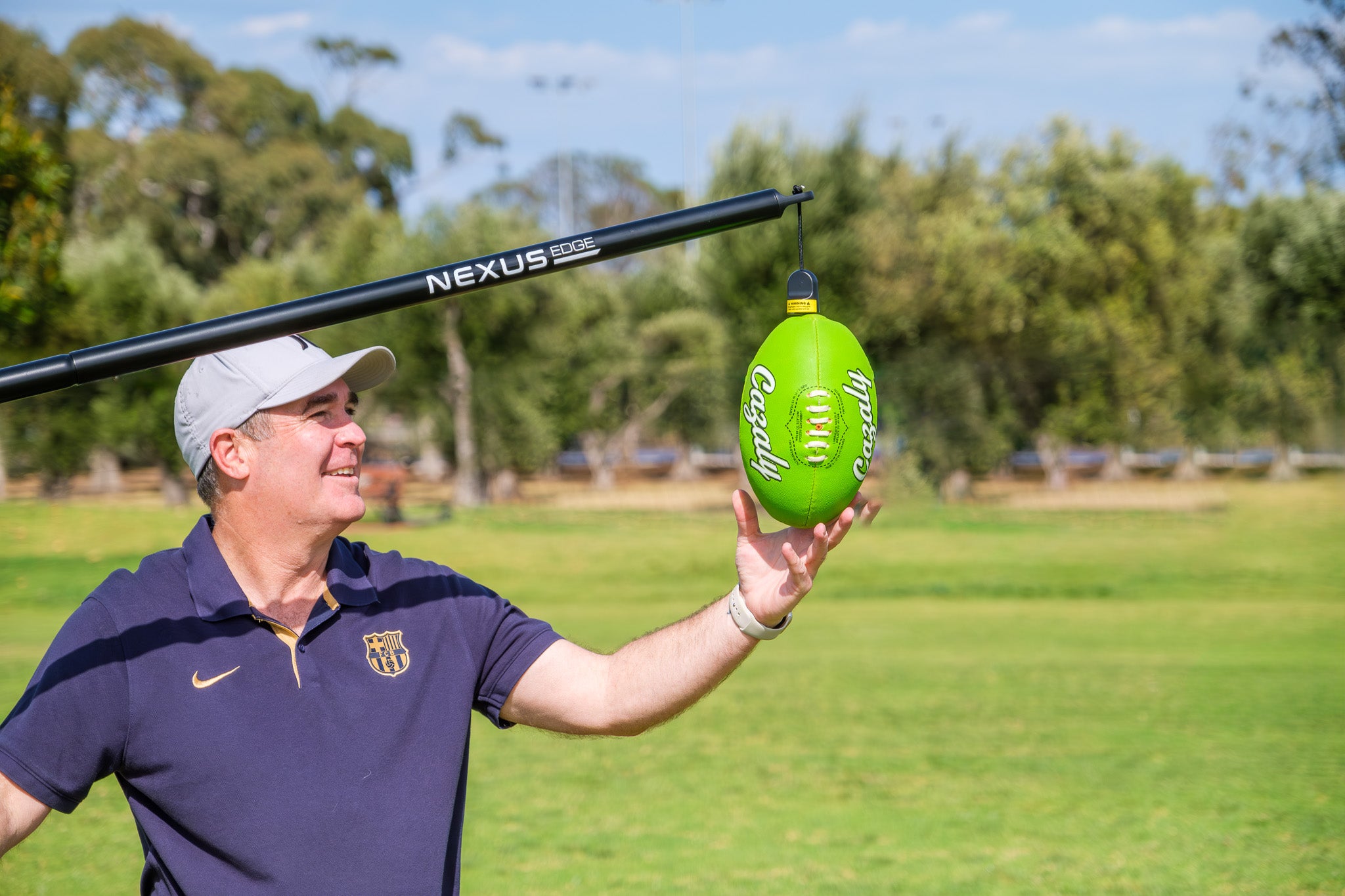 A person prepares the Nexus Edge Cazaly ball ready to practise AFL skills using the Nexus Edge