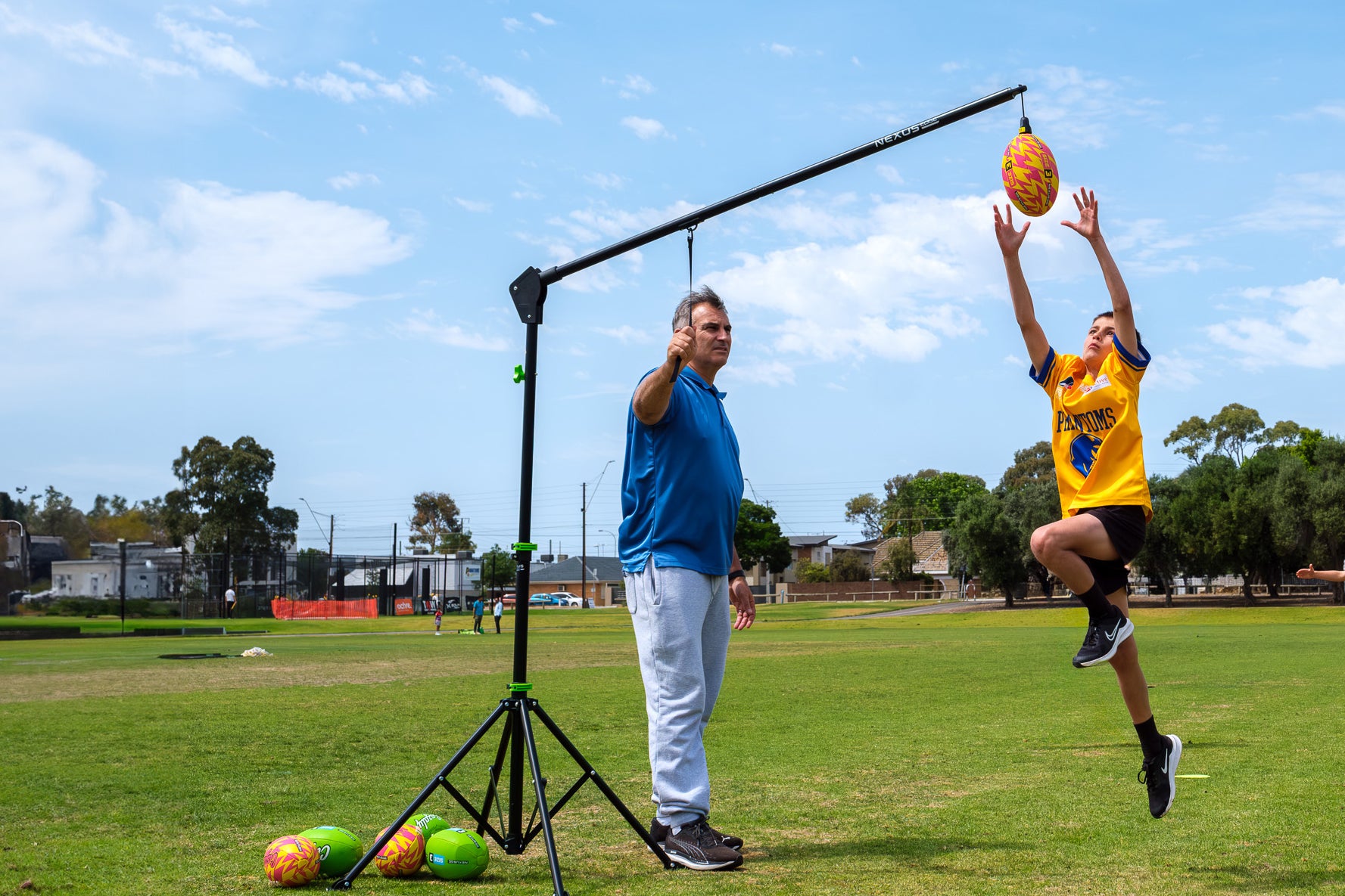 A child leaps into the air to practise their AFL marking skills using the Nexus Edge