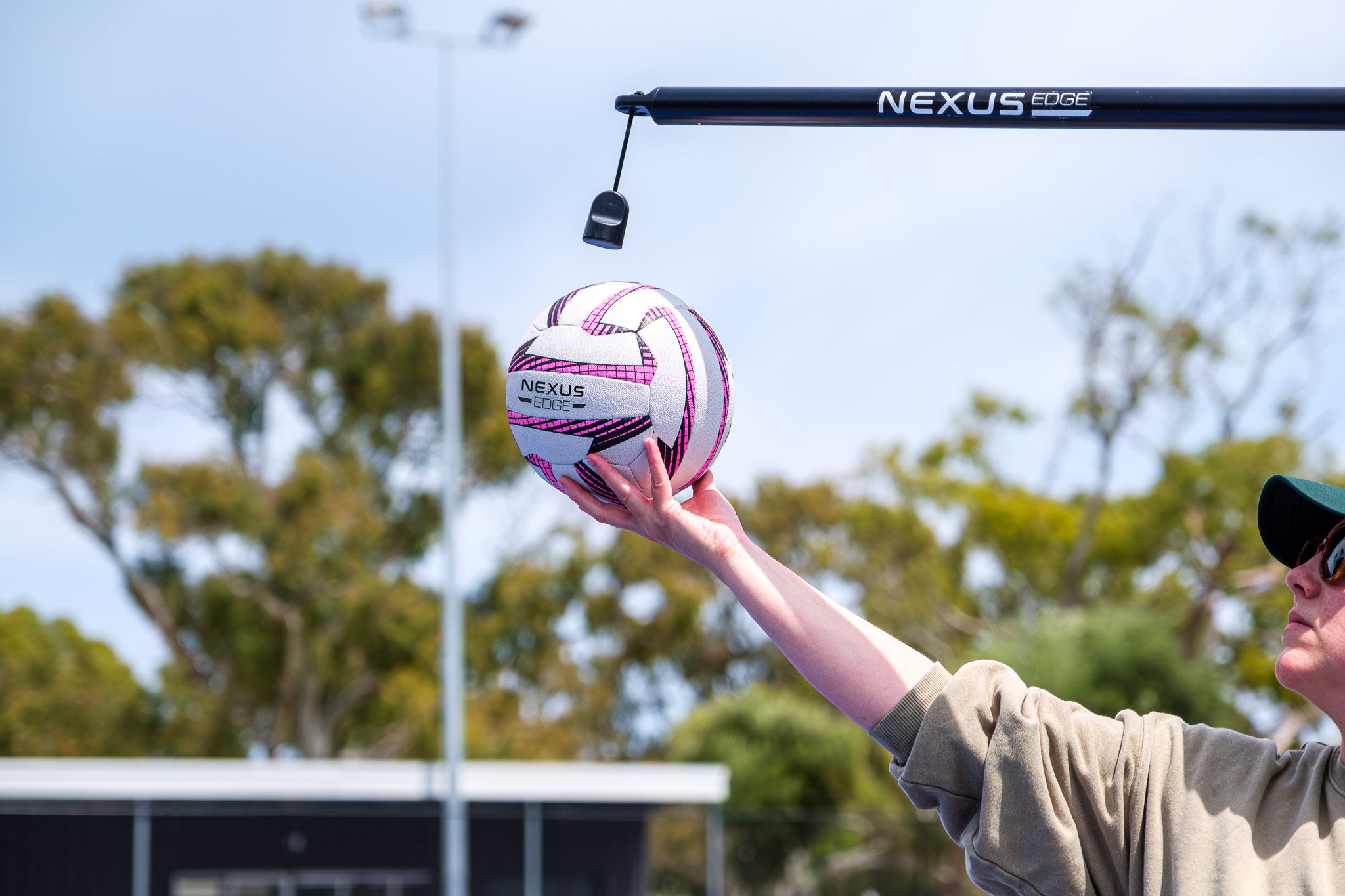 A person hold a Nexus Edge netball to set up for netball skill practice